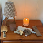 Cozy Scrunchie in Heather Cloud Knit on side table with assorted hair care and accessories