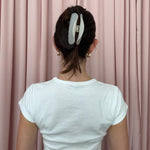 back view of model standing in front of pink curtain with Half Moon Clip in Grey Smoke in hair