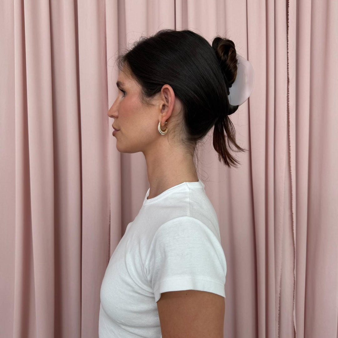 profile view of model wearing Half Moon Clip in Pink Smoke in front of pink curtain