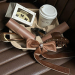 Assorted Emi Jay hair care and accessories in coffee tray with Emi Jay coffee cup.