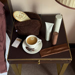 Assorted Emi Jay hair car, accessories, and pouch on table with coffee.