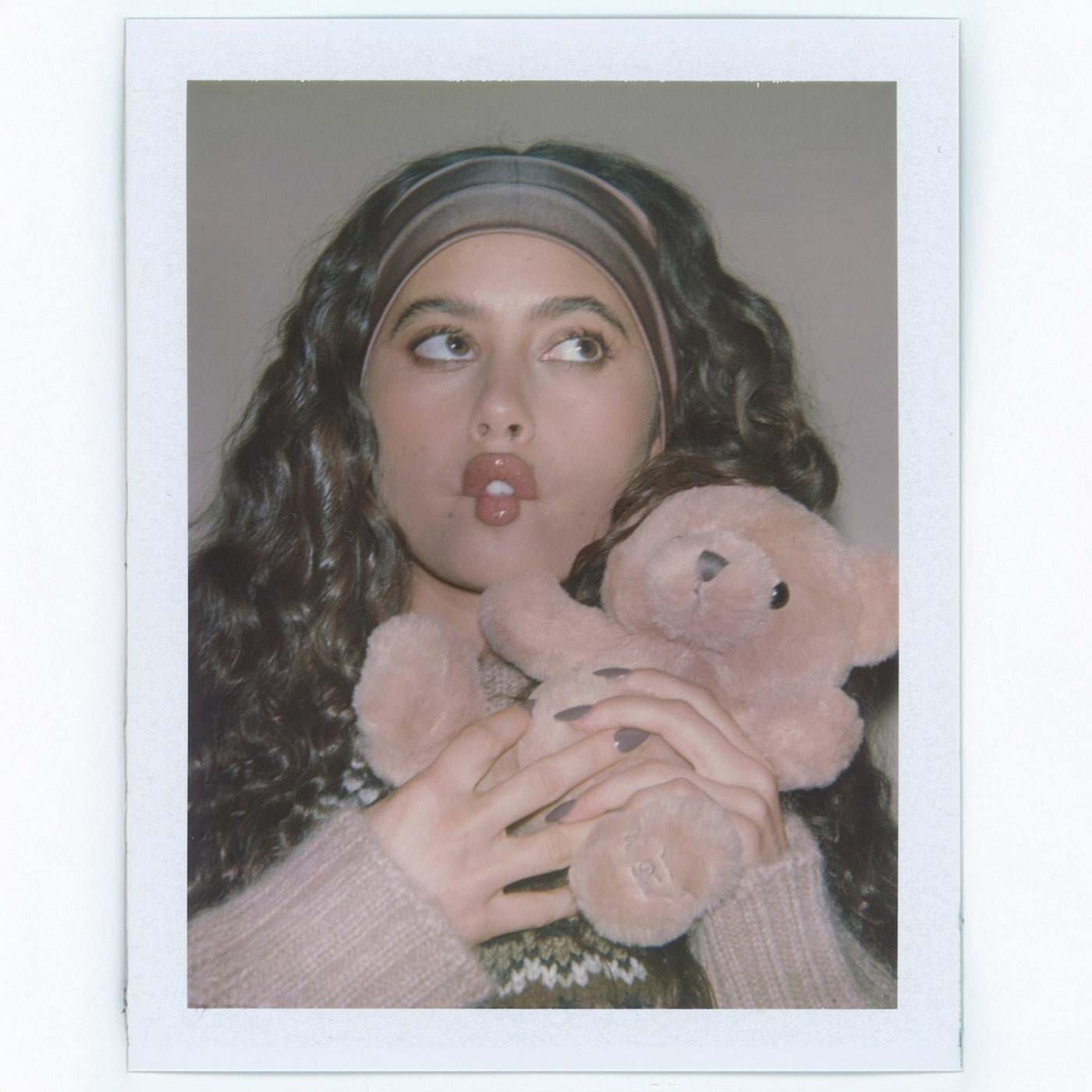Polaroid of model wearing Infinity Headband in Mousse while holding teddy bear.