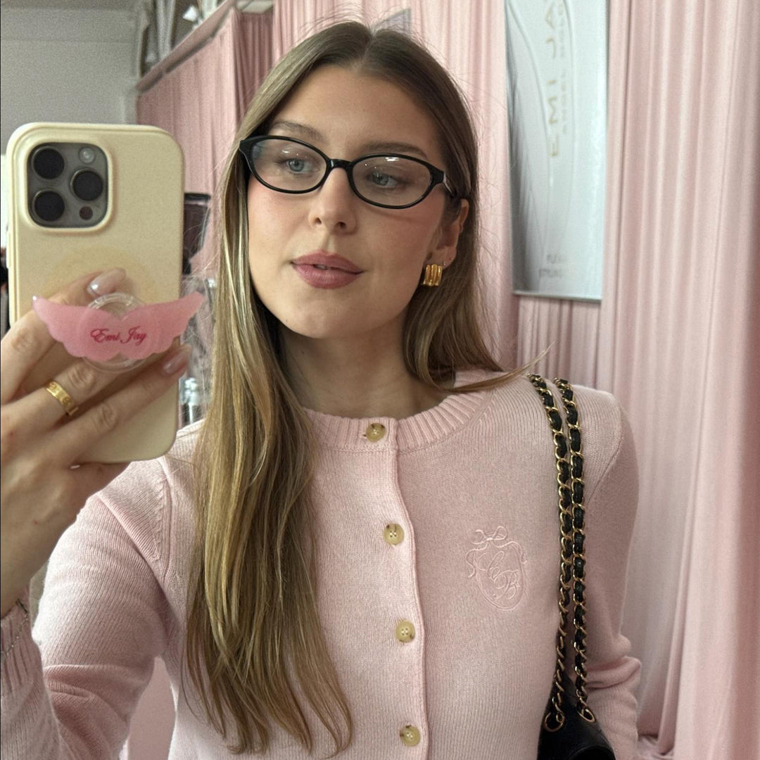 model standing in front of pink curtain holding phone with Limited Edition Angel Phone Grip