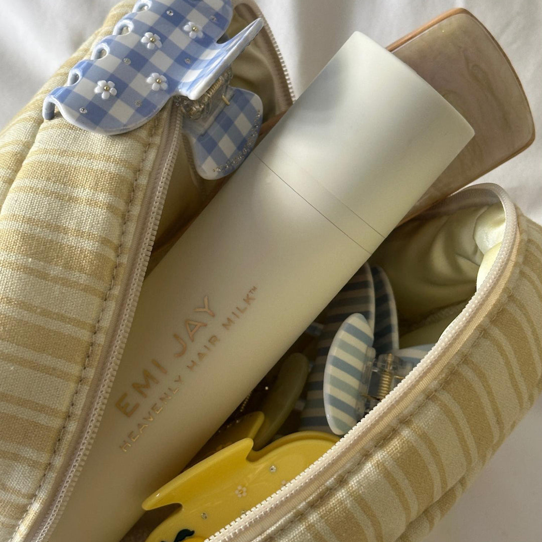 Linen Pouch in Out of Office filled with assorted hair accessories and heavenly hair milk