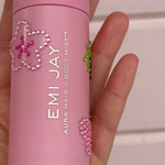 model holding aura hair + body mist in Lychee Baby bottle with stickers on it