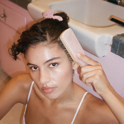 model brushing hair with Mini Boar Bristle Brush in Pink Sugar