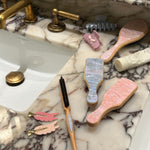 Popstar Clips in Pink Aura sinkside next to brushes and hair accessories