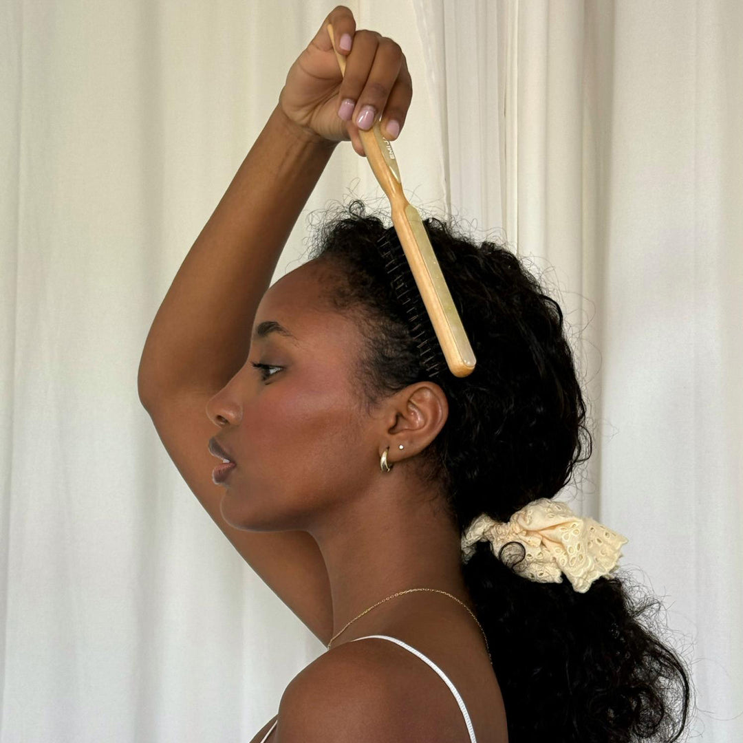 model brushing hair with styling brush in lemon sugar