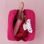 Terry Pouch in Lychee Baby holding aura hair + body mist in lychee baby, hair clips, and brush