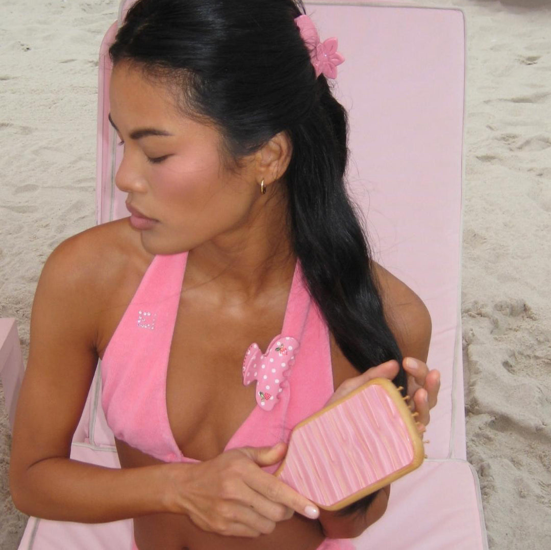 model wearing hair pin brushes hair with Bamboo Paddle Brush in Lychee Baby