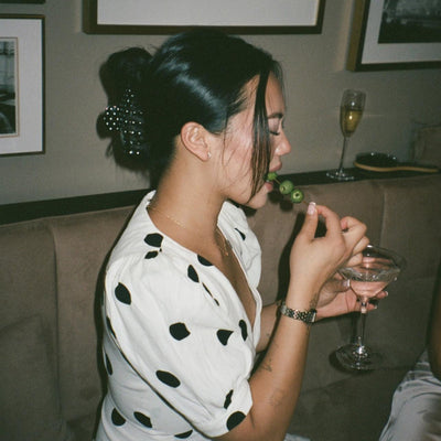 model earing olives from martini while wearing Big Effing Clip in Noir Polka Dot in hair