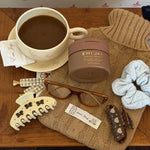 Big Effing Clip in S’more Love with assorted hair care and accessories next to Emi Jay coffee