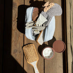 cozy pouch with assorted emi jay hair care, accessories, and snow sugar bamboo paddle brush