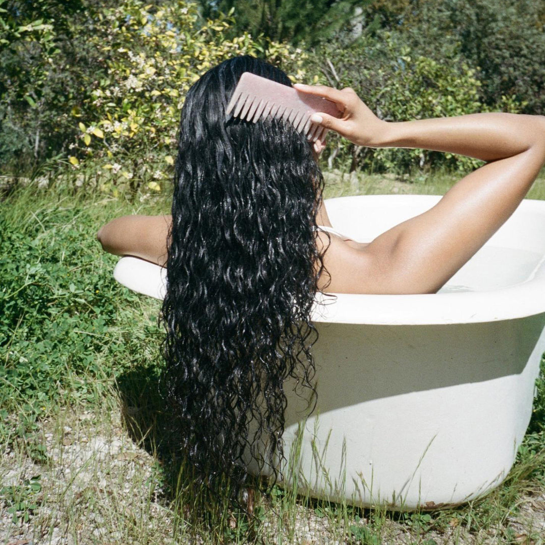 model in bathtub using Detangling Comb in Pink Sugar in hair