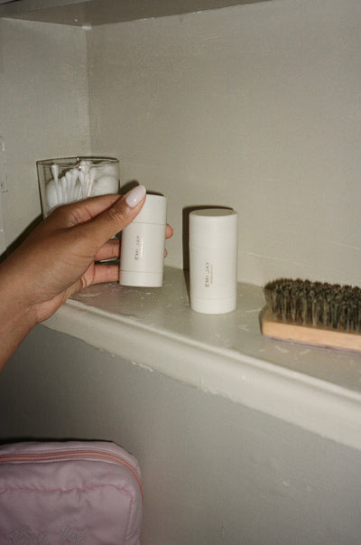 model reaching towards a shelf above an emi jay pouch to pick up one of the angelsticks next to a mini boar bristle brush