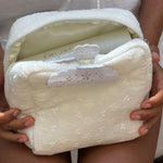 model holding Eyelet Pouch in Blanc Daisy with clip attached