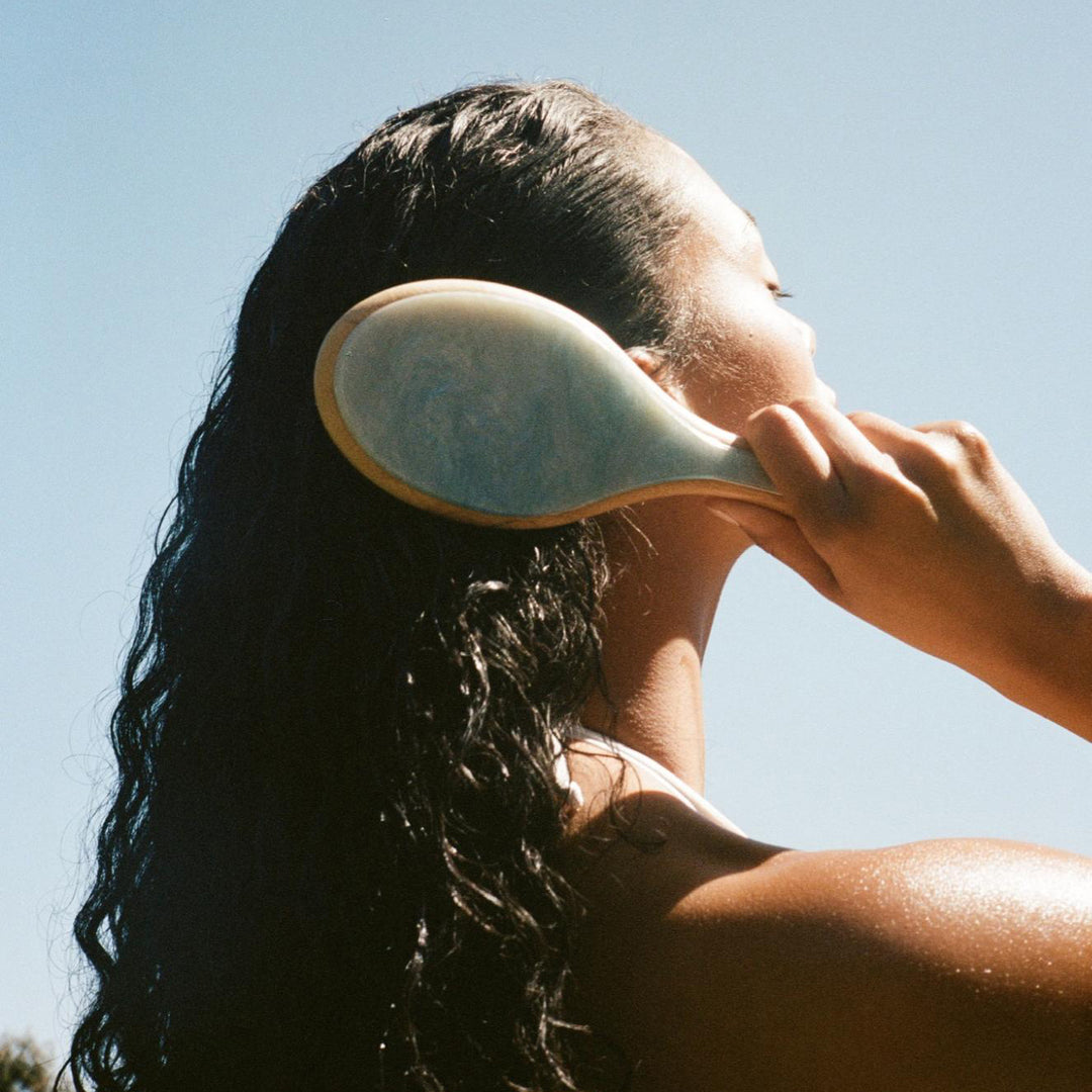model brushing hair with Flat Brush in Blue Sugar