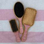 assorted Lychee Baby hair brushes on pink and white striped towel