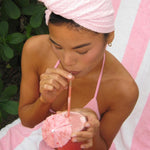 model drinking out of straw while wearing Heavenly Hair Towel in Lychee Baby