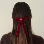 model wearing Iconic Velvet Bow Barrette in Cabernet in hair