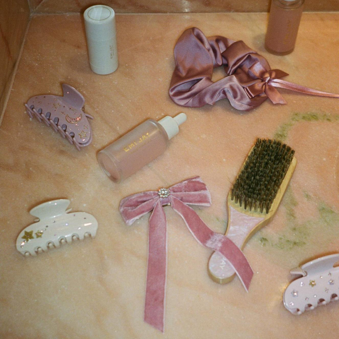 Iconic Velvet Bow Barrette in Baby Mauve, darling scrunchie in rosewood, angelstick, mini boar brush in pink sugar, halo hair oil, big effing clip, and sweetheart clips