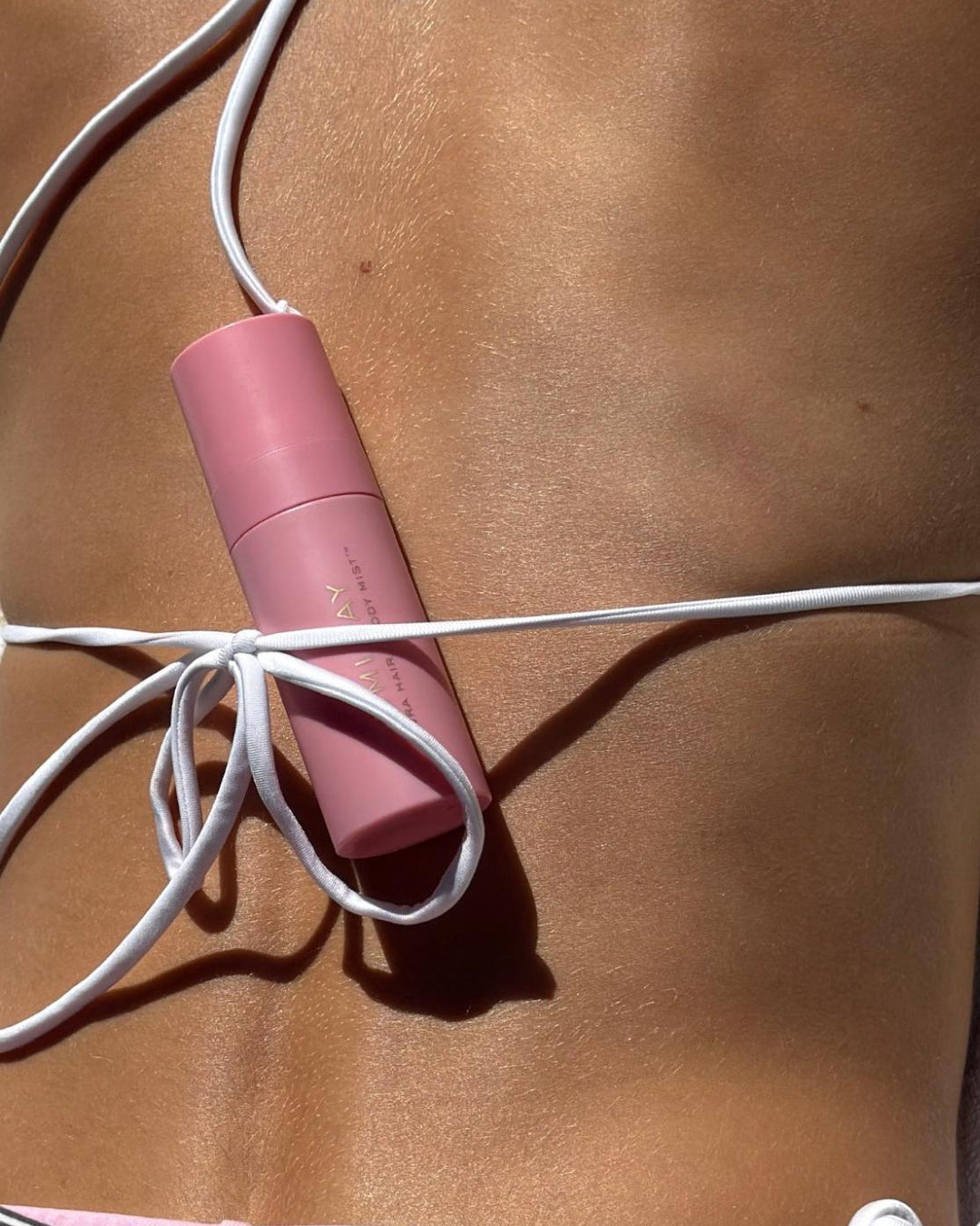 model with Aura Mist in Lychee Baby under strap of bikini on her back