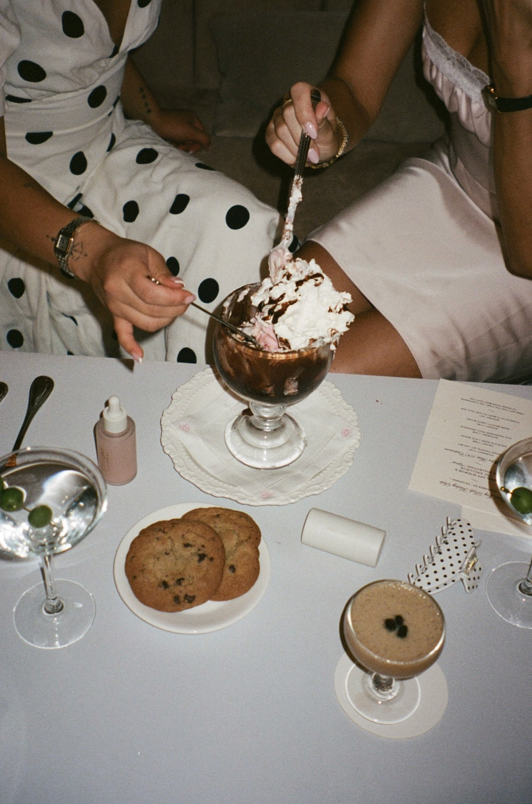models sharing a sundae next to martinis, cookies, hair care, and a big effing clip