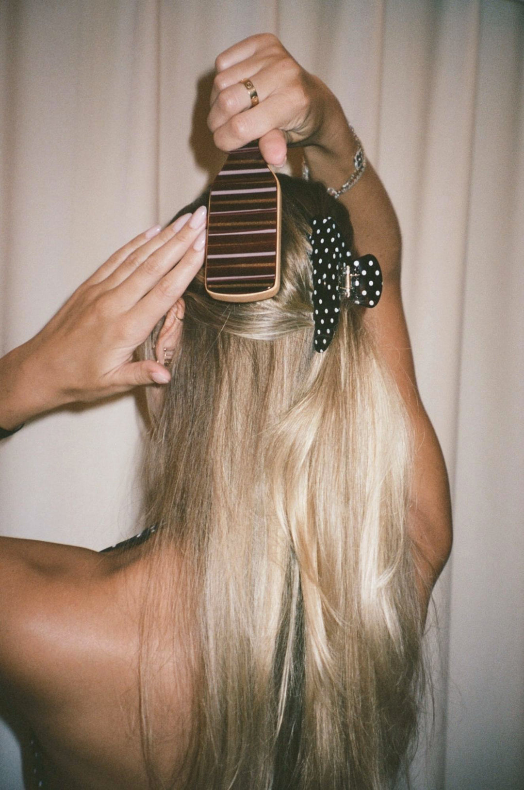 model brushing hair with mini boar brush while wearing big effing clip