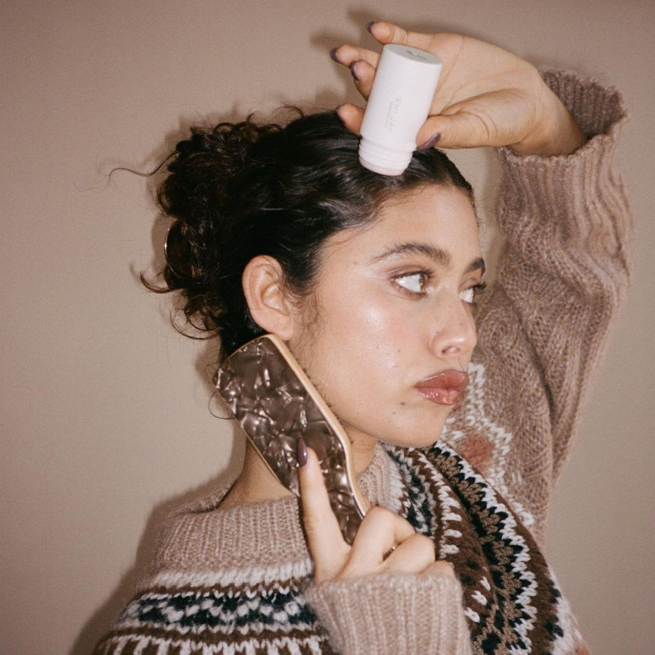 Model applying angelstick to hair while using Mini Boar Bristle Brush in Toasted Sugar.