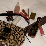 assorted emi jay hair care and accessories with animal print bag and contents