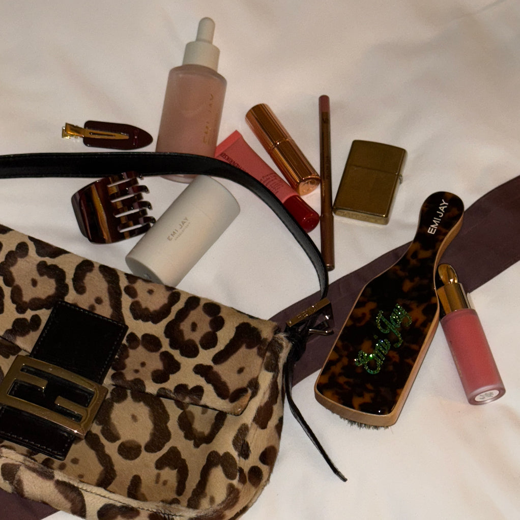 assorted emi jay hair care and accessories with animal print bag and contents