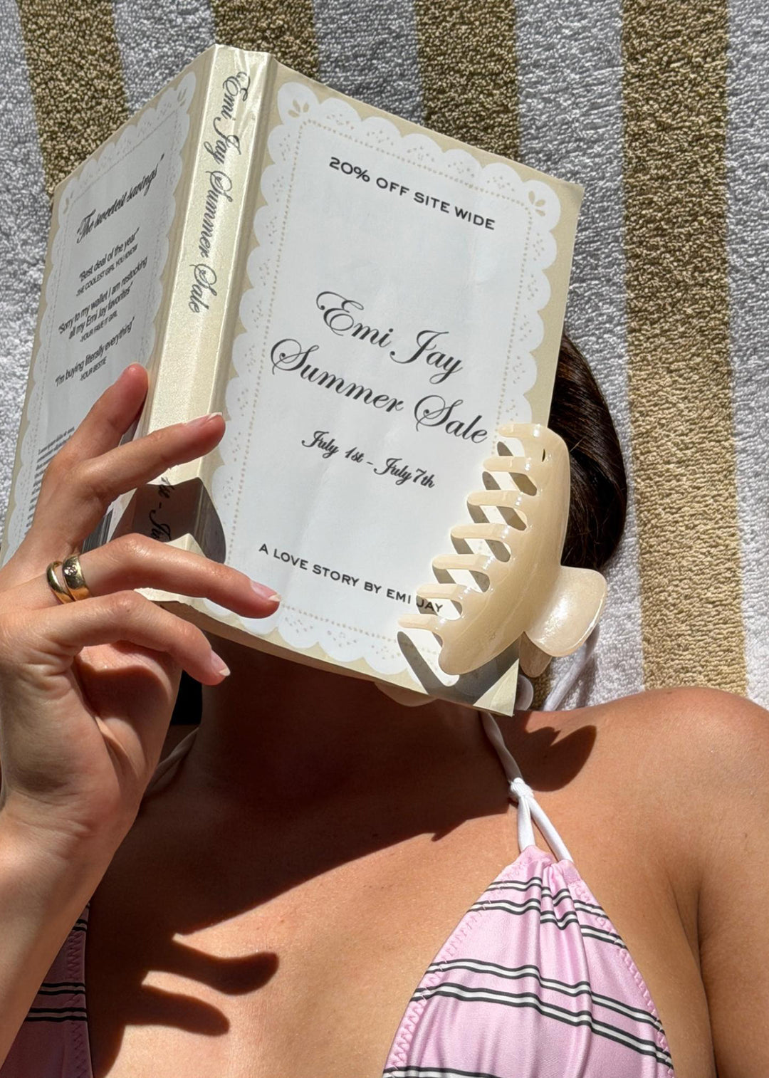 model reading Emi Jay Summer Sale book with big effing clip attached as bookmark