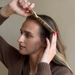 Closeup of model brushing hair with Styling Brush in Toasted Sugar.