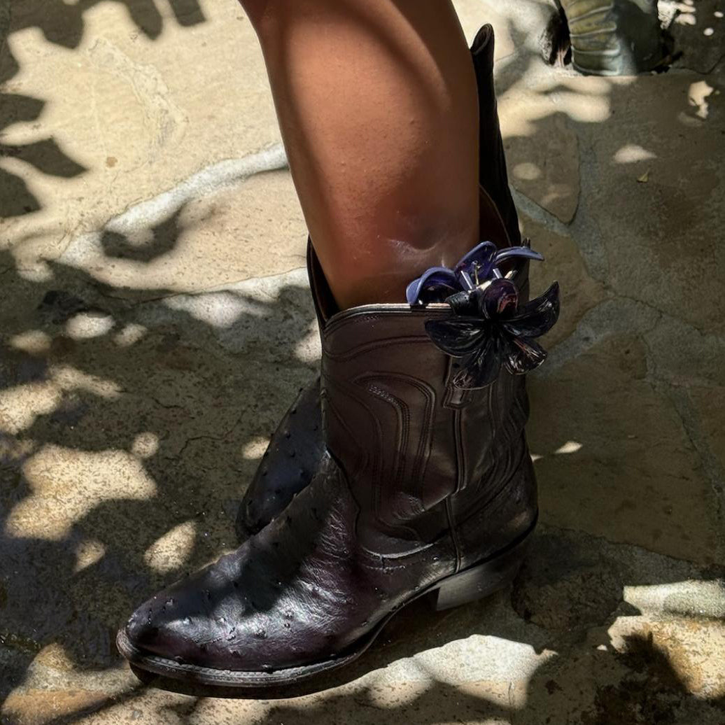 model wearing Super Bloom Clip in Blackberry attached to boot