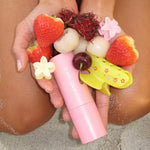 model holding assorted fruit, aura hair + body mist in lychee baby, and hair clips