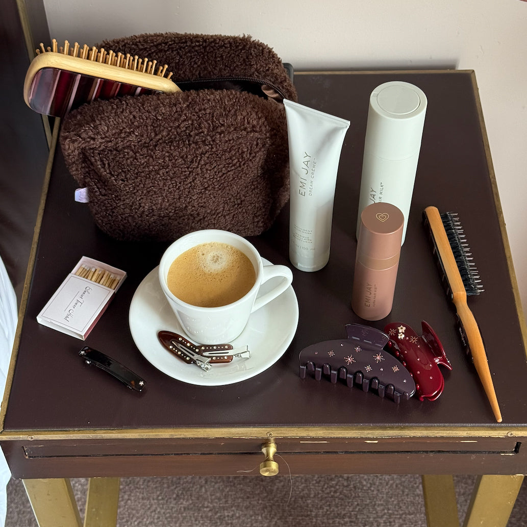 assorted emi jay hair care and accessories next to coffee and matches on side table
