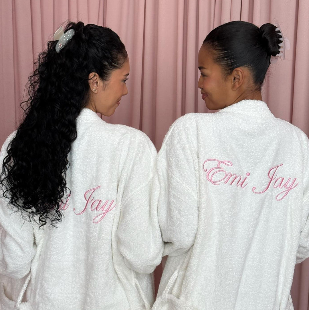 models wearing emi jay robes and claw clips standing in front of pink curtain