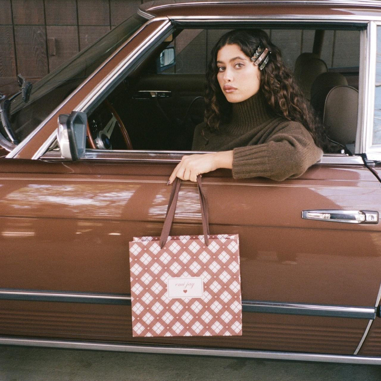 Model sitting in car and holding Toasted Sugar Gift Bag.