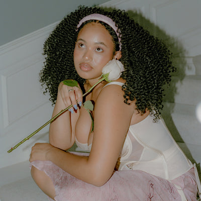 model on staircase wearing Halo Headband in Pink Embroidery