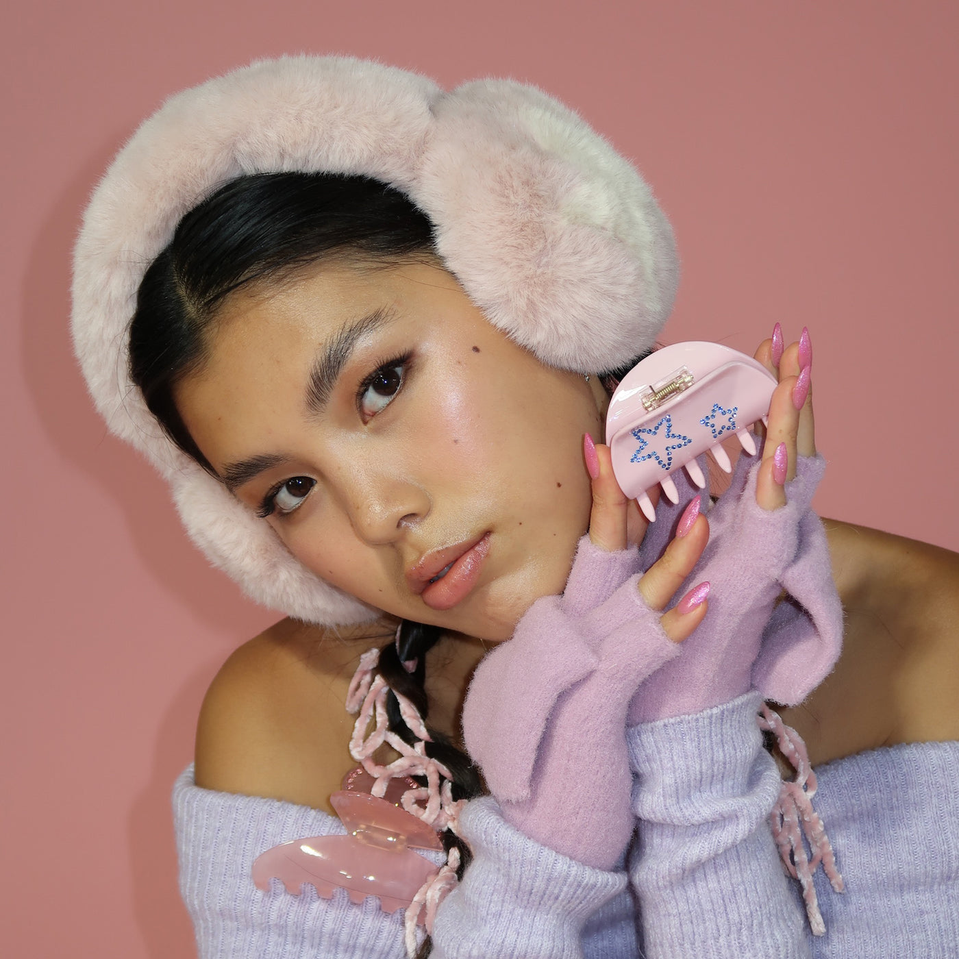 model holding Sweetheart Clip in Pink Flurry while wearing Sugar Muffs