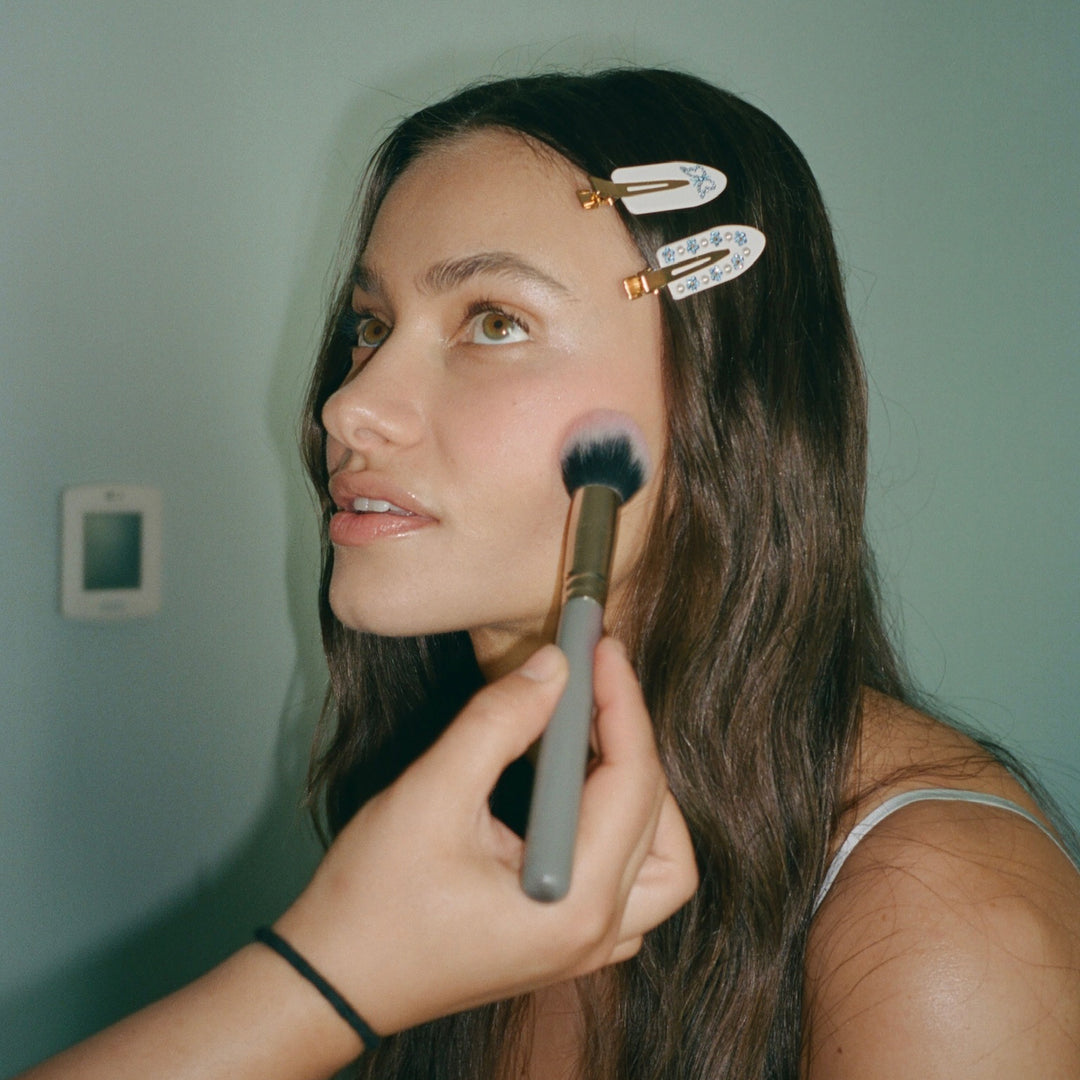 model getting makeup done with Popstar Clips in Fairytale + Flutters in hair