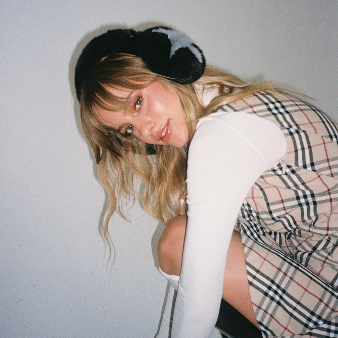 model sitting while wearing Sugar Muffs in Black Diamond