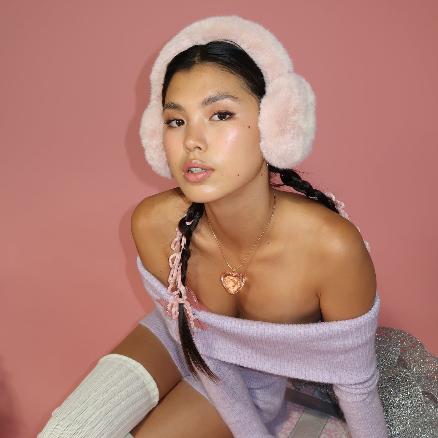 model sitting while wearing Sugar Muffs in Frosted Pink